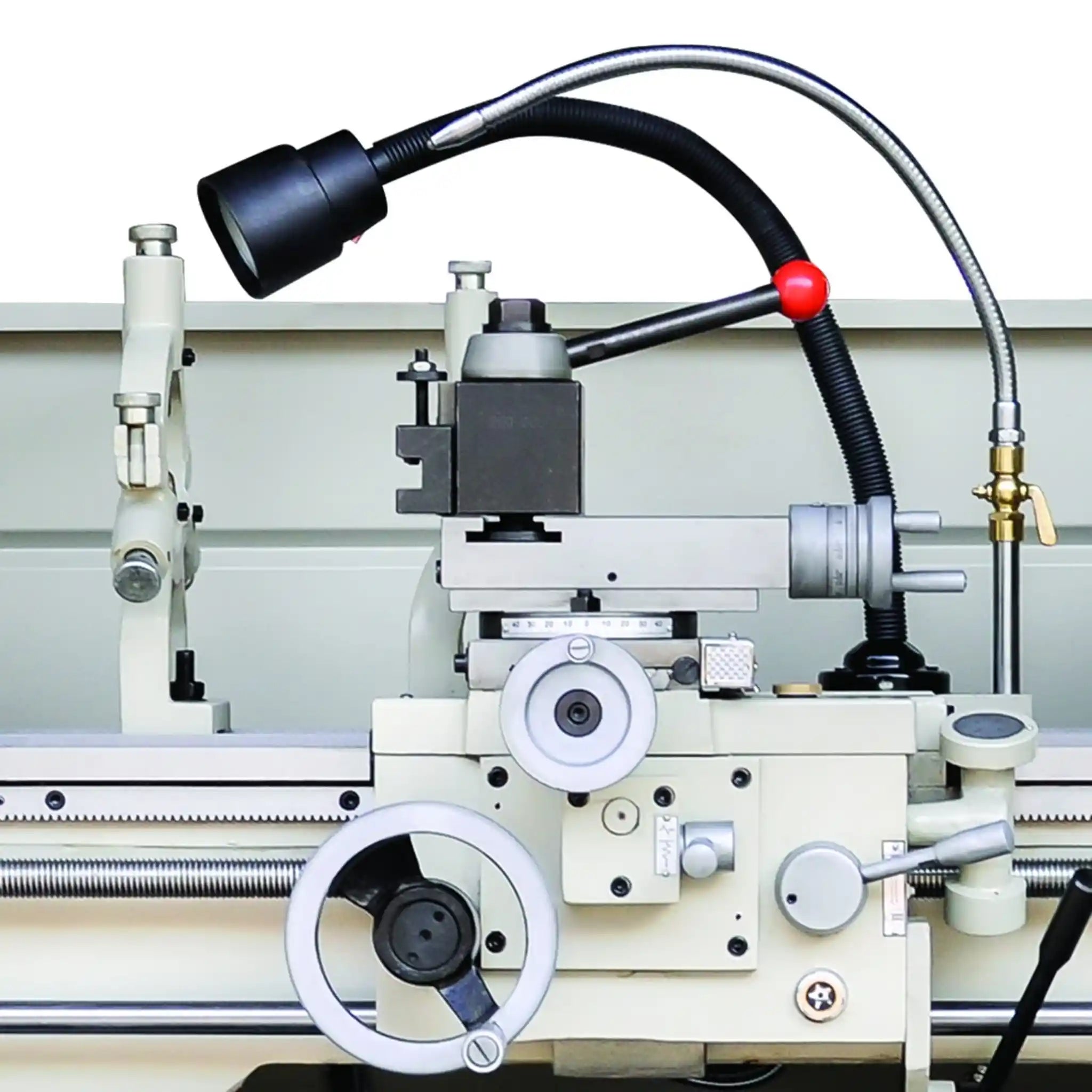 A close up image of the carriage and tooling, the image also shows the work light and some manual wheel controls, the lathe is the PL-1236E-DRO, manufactured by Baileigh